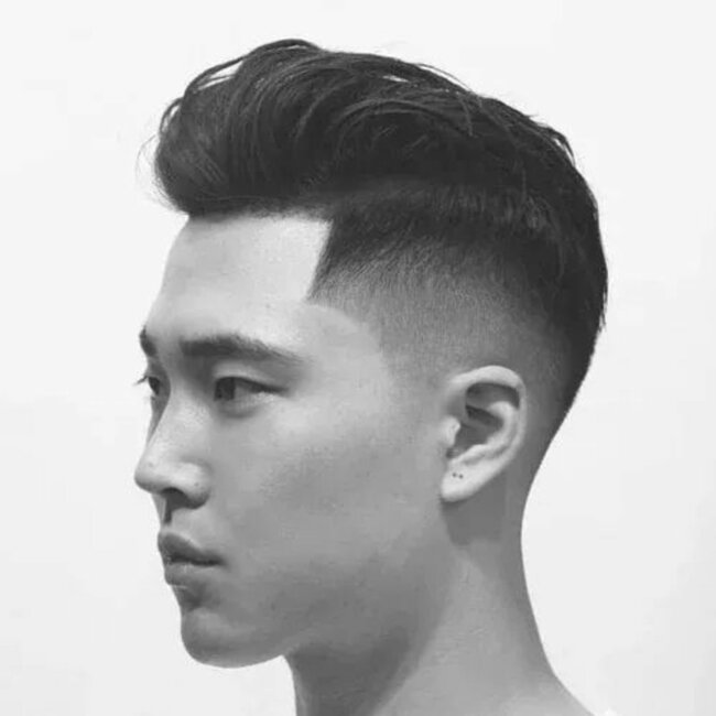 A bold and edgy haircut featuring a short pompadour. 