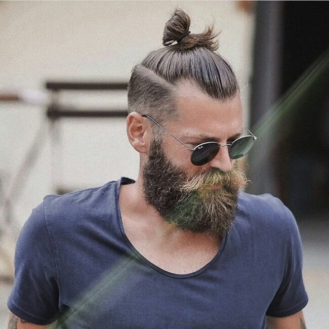 A bold look with top knot with beard. 